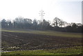 Electricity pylons cross a ploughed field