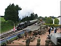 Steam train approaching Churston Station past the military display