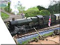 Steam train passing under the bridge at Churston Station