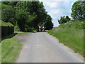 Cyclists on Okehurst Road having just passed Frogs Hole Cottage on their left