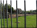 View through safety fence to thatched barn at Broadhurst Manor