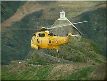 SS5247 : The RAF rescue helicopter passing by  St. Nicholas' chapel on Lantern hill by Roger A Smith