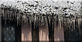 Icicles along the eaves of a thatched cottage
