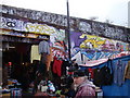 View of graffiti on East London Line viaduct and shop front on Sclater Street