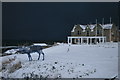 Moray Golf Club house at dusk under snow-laden skies