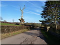 Road scene with sculpture-tree, near Llanhennock