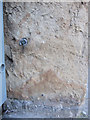 Badly damaged bench mark and bolt on Flint Town Hall