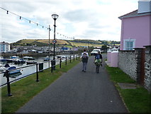 SN4562 : Walkers beside the harbour in Aberaeron by Jeremy Bolwell