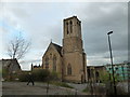 Pedestrian passing a disused church as seen from Hollis Croft