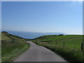 SY7482 : Road down to Ringstead by Alex McGregor