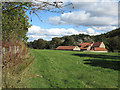 House with outbuildings across field