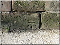 Bench mark on the riverside wall