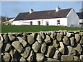 Traditional farm cottage bounded by a Down single dry stone wall