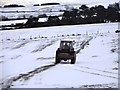 NZ0744 : Tractor in snowy fields by Robert Graham