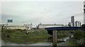 View of the Olympic Stadium, Arcelo-Mittal Orbit sculpture and flats on Stratford High Street from the House Mill garden