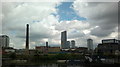 View of two old factory chimneys and flats on Stratford High Street from the Lea Navigation