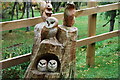 A family of Owls and squirrels all carved out of a tree stump