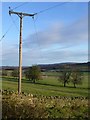 NU0916 : Electricity pole beside a dry stone wall by Russel Wills