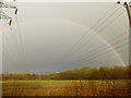 Field with poles, pylons and rainbow