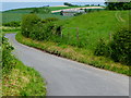 Farm buildings seen from road below Coombe Cross