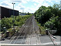 Distant train speeds towards Coedcae Lane level crossing, Pontyclun