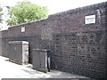 TQ2782 : Brick wall with signs warning of anti climb paint, north end of Harewood Avenue by Robin Stott