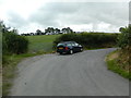 Sharp bend and farm gate on the road east from Oakford