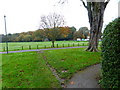 Looking west across cricket ground to small building