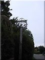 Chattisham village sign obscured by a conifer