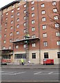 Workers descending on a platform lift on the outside of Days Hotel in Sandy Row