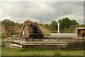 View of a water wheel and fountain in the Redbridge Fishing Lakes