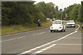 View of a Beetle and Lotus Cortina Mark II passing along London Road as part of the London to Southend Classic Car Run