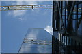 View of a construction crane reflected in Neo Bankside Apartments