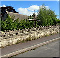 Wooden cross at a churchyard perimeter wall, Brimscombe