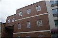 View of mosaic windows on a block of flats on Brick Lane