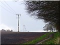 Power lines in a ploughed field beside the Robin Hood Way