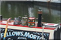 View of colourful painted buckets on top of Lupin No. 67 from the Grand Union Canal towpath