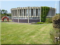 Circular building beside strange red pipe