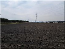 TQ1863 : Ploughed Field and Pylons by James Emmans