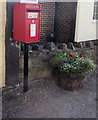 Queen Elizabeth II postbox and a flower tub, High Street, Aylburton