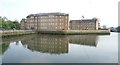 View of apartment blocks at Town Quay Wharf reflected in the Roding