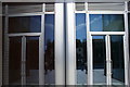 View of the entrance to the office block reflected in the spike of the office block in Paddington Basin