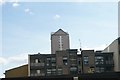 View of a towerblock in The Quarterdeck development peeking above low-rise apartments on Manilla Street from Cuba Street