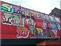 View of "Shimmering and Dirty" street art on the side of the Fiction night club from Havana Close