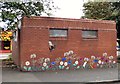 Bee and flowers on toilet block wall