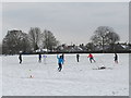 Informal football on snowy playing field, North Acton