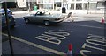 View of a Mercedes Benz 350SL pulling away from the traffic lights at Eltham Church on Court Road