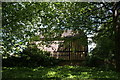 View of a house on Court Yard through the trees from the garden of Eltham Palace