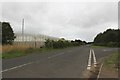 Road passing the boundary fence of Northumberland Prison