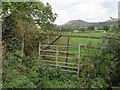 A rusty gateway, a bench mark, and a view to the hills